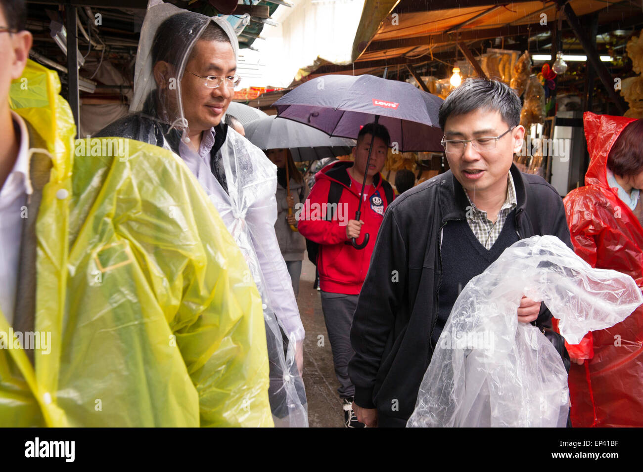 Die Touristen tragen regen Bekleidung im Fischerdorf Tai O auf Lantau Island, Hong Kong, China. Stockfoto