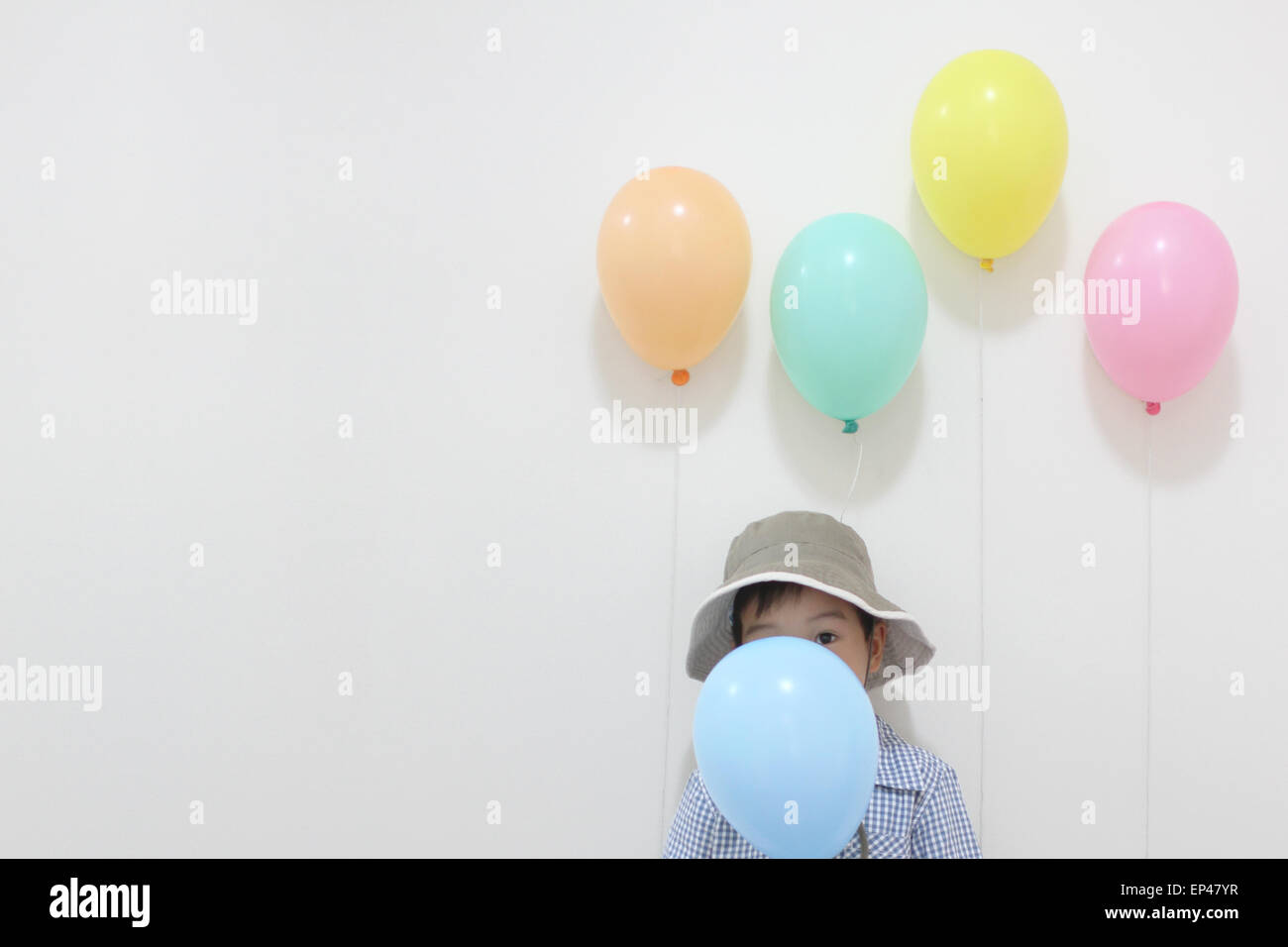 Junge versteckt sich hinter einem Partei-Ballon Stockfoto