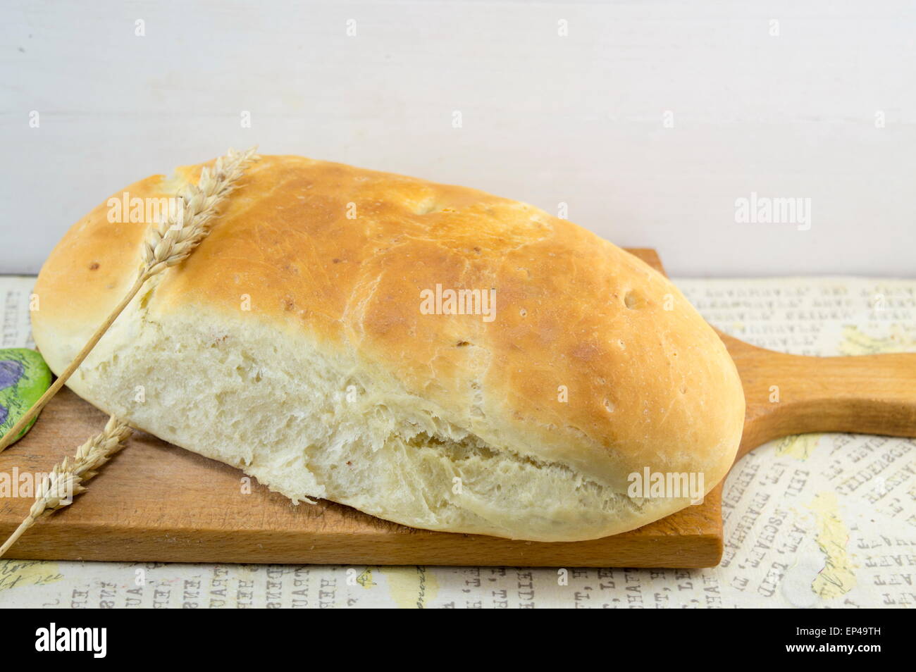 Hausgemachte frisch gebackenes Brot auf ein Schneidebrett mit Weizen Stockfoto