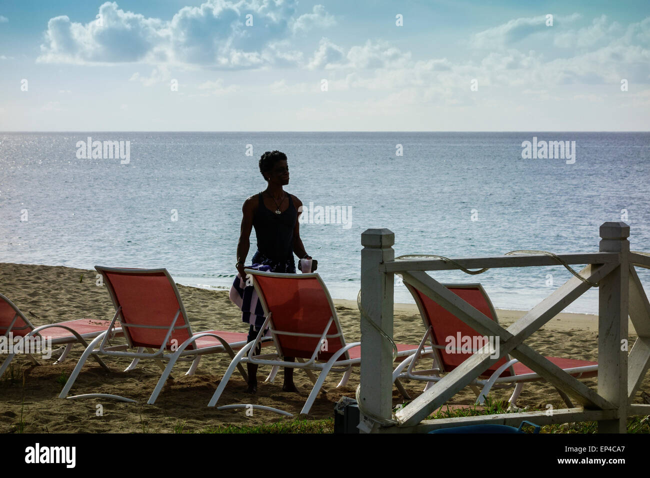 Ein afrikanischer amerikanischer Junge grüßt die Morgendämmerung für einen frühen Schwimmen am Strand von Sandcastle auf St. Croix, Amerikanische Jungferninseln. Stockfoto