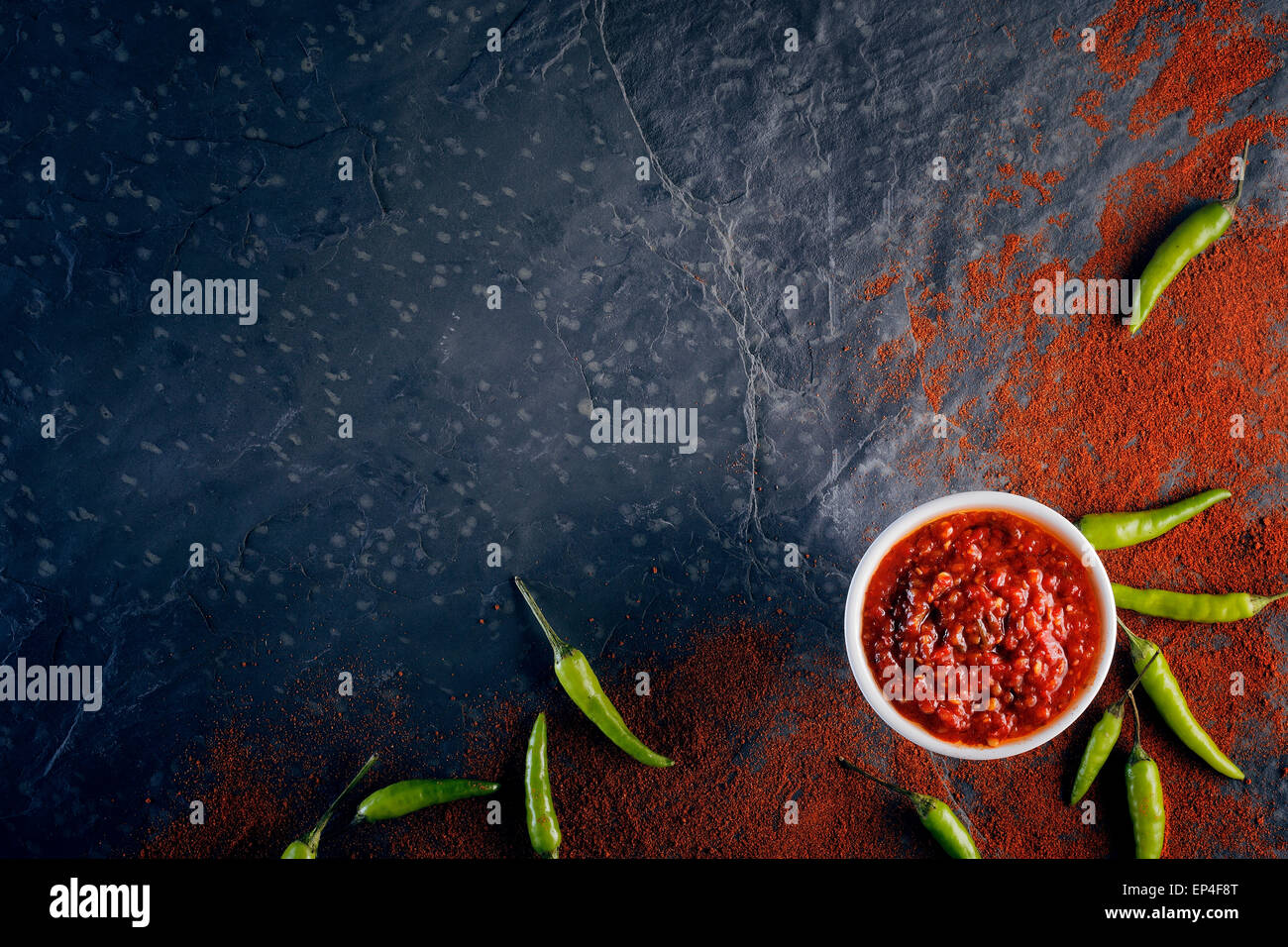 Chili und Knoblauch lustvoll auf schwarzem Schiefer Hintergrund von oben Stockfoto