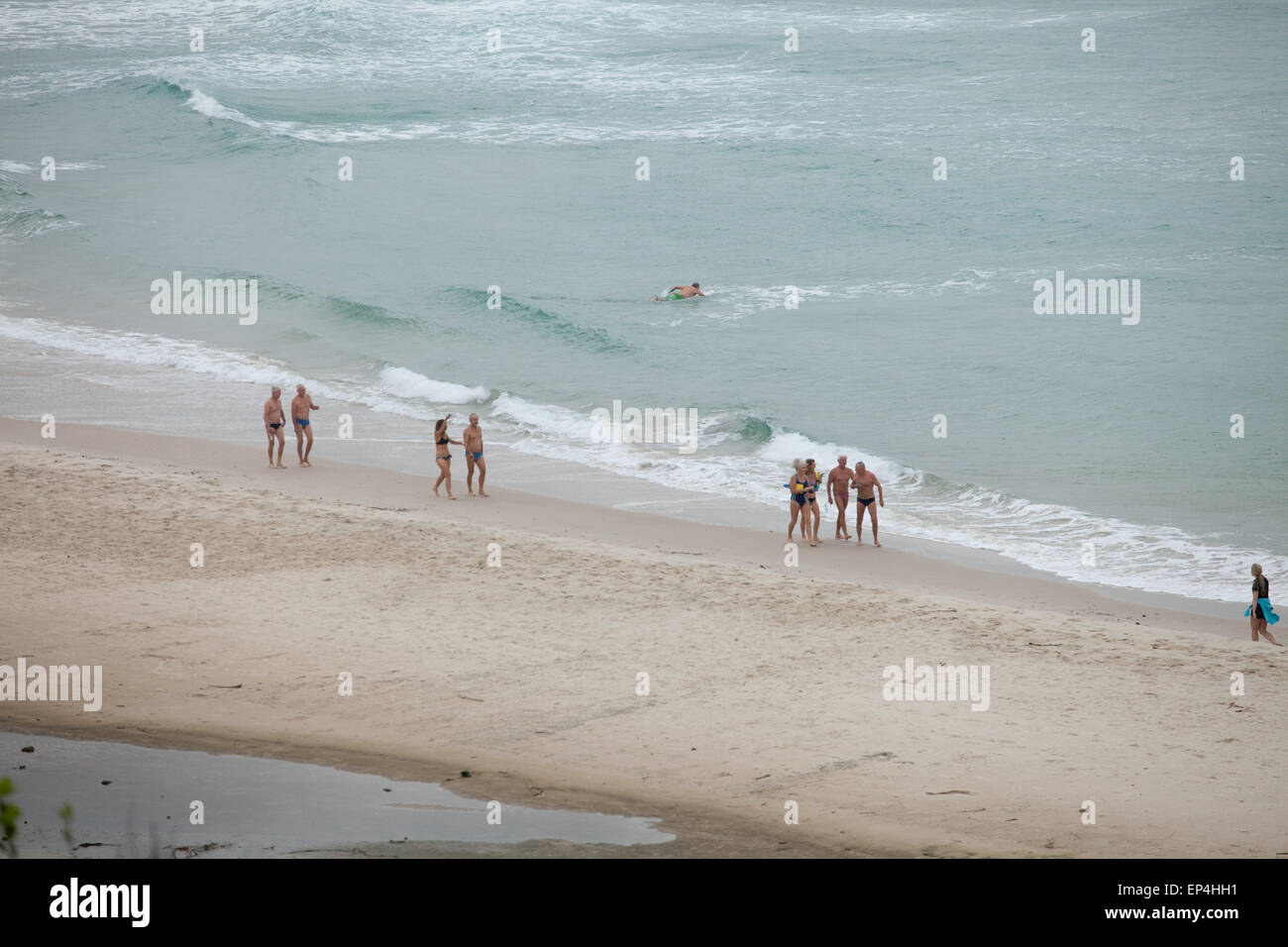 Starke Schwimmer Fuß am Strand entlang nach ihrer langen Schwimmen im Ozean in Byron Bay, Australien. Stockfoto
