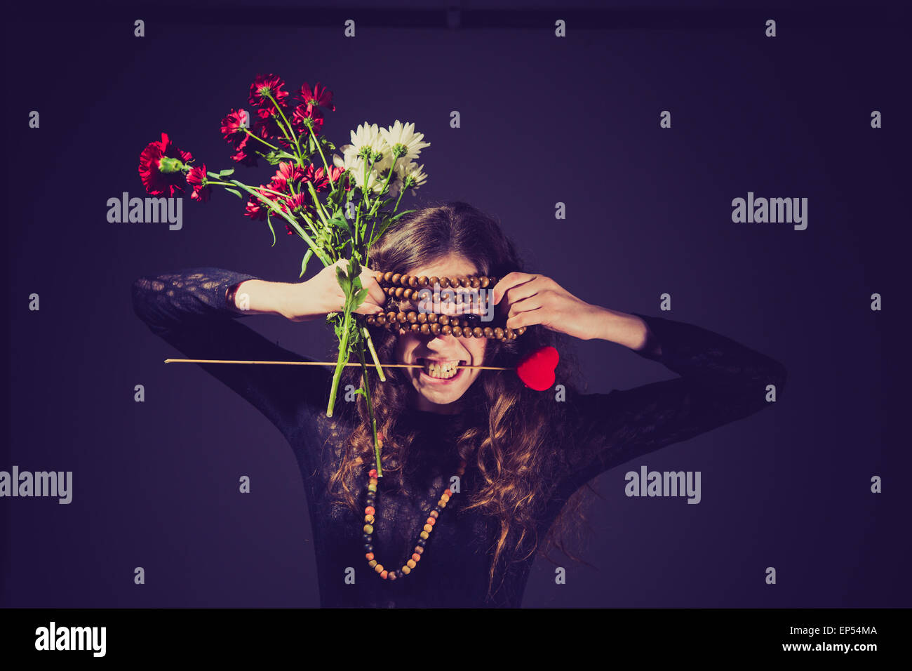Eine junge Frau mit Blumen in den Händen und eine Grimasse auf ihrem Gesicht. der Schönheit auf Valentinstag lassen hat? Stockfoto