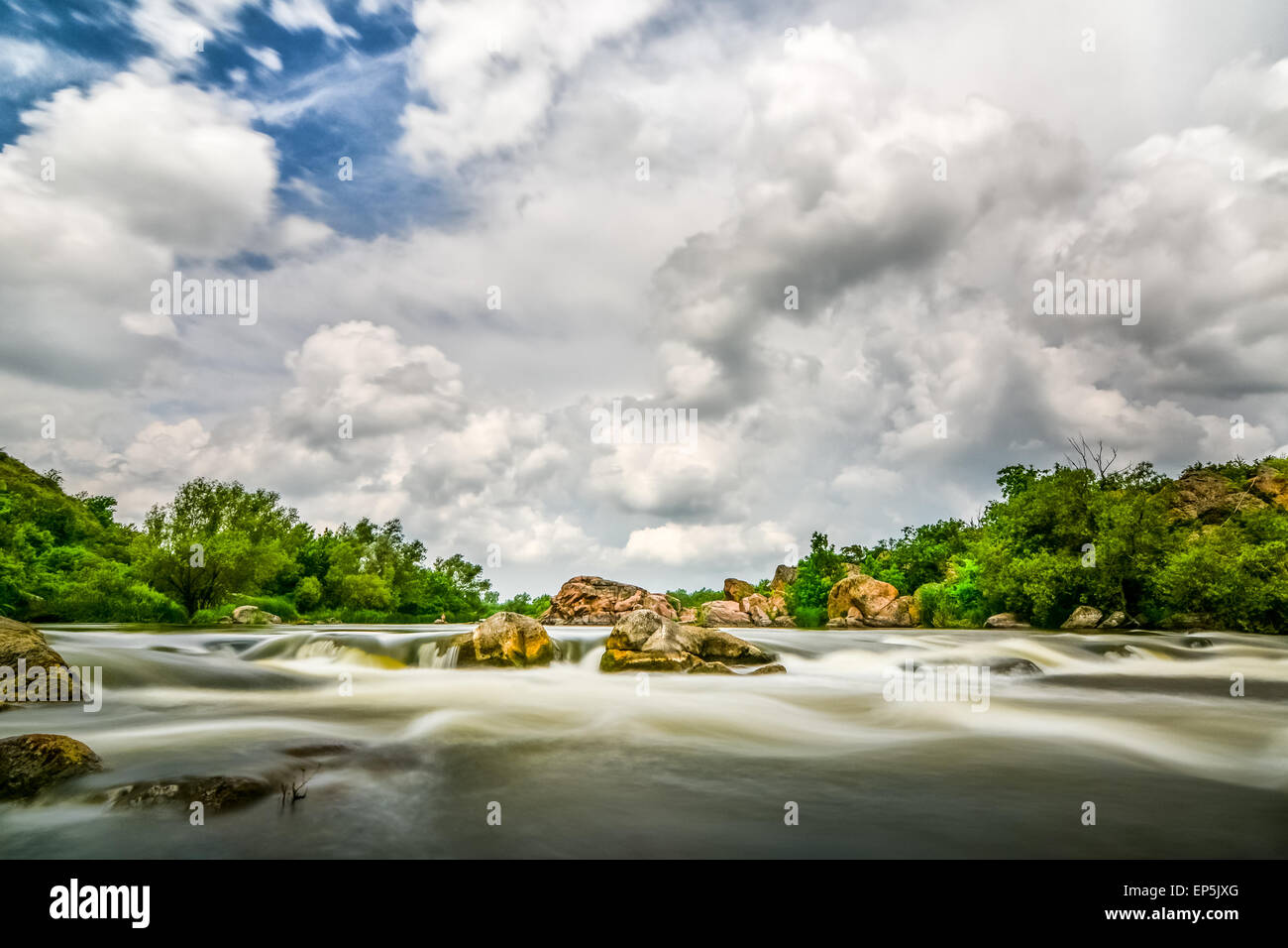 Schöne Fluss mit stürmischen Himmel Wolken, Felsbrocken in bewegtem Wasser - Langzeitbelichtung Stockfoto