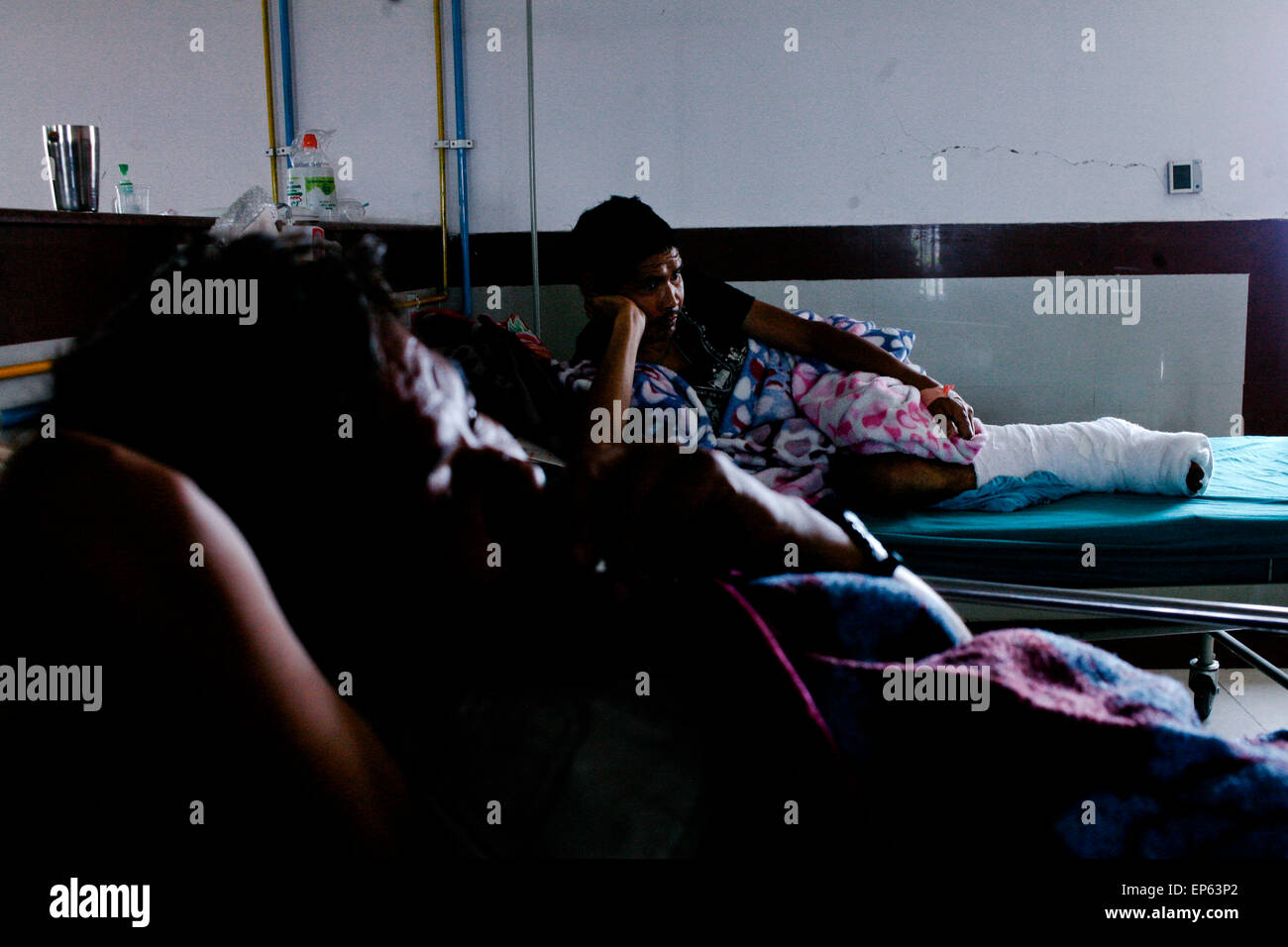 Eine verletzte nepalesische Überlebende schlafen im Krankenhaus in Kathmandu. Ein massives Erdbeben der Stärke 7.4 getroffen Nepals Hauptstadt Kathmandu am Dienstag, Auslösung von starken Erschütterungen, die in Delhi und anderen Teilen von Nordindien zu spüren waren. (Foto von Khairil Safwan / Pacific Press) Stockfoto