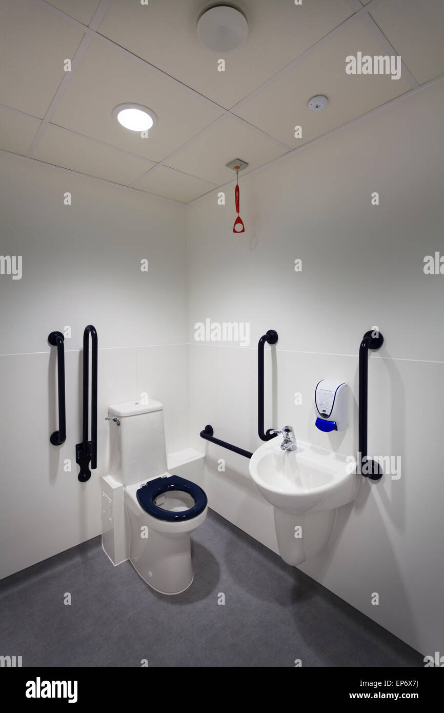 Unbesetzten behindertengerechte Toilette mit Becken und greifen Handläufe Stockfoto