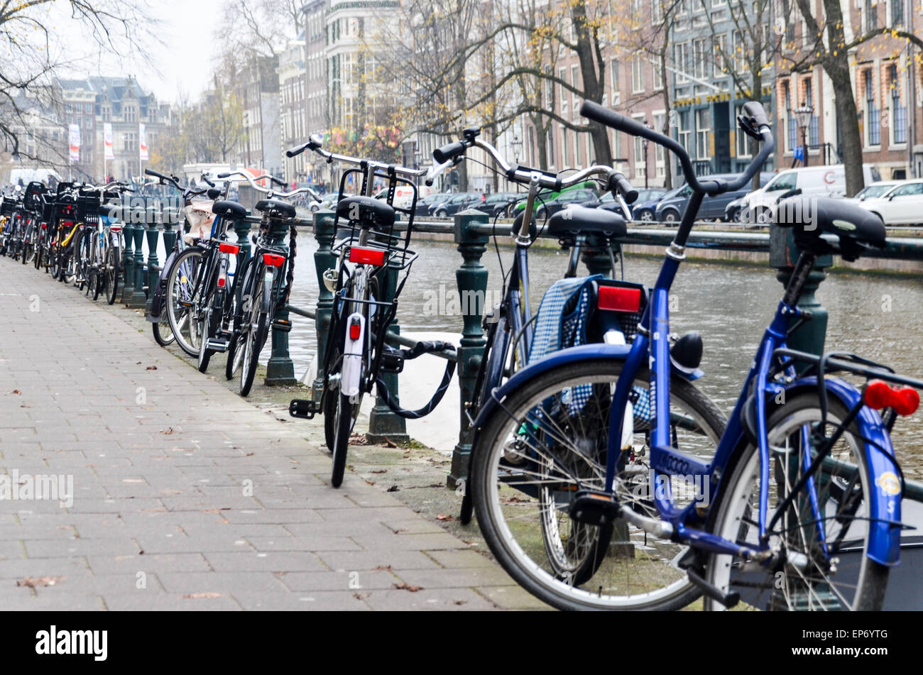 Fahrräder geparkt an einem Kanal in der Innenstadt von Amsterdam, Niederlande Stockfoto