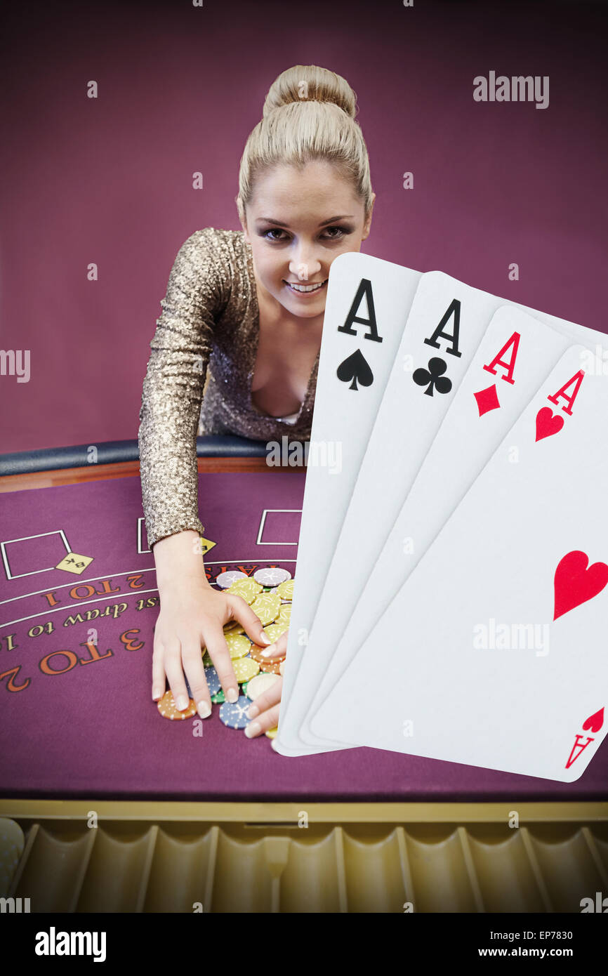 Blonde Frau packte Chips mit digitalen Hand vier Asse Stockfoto