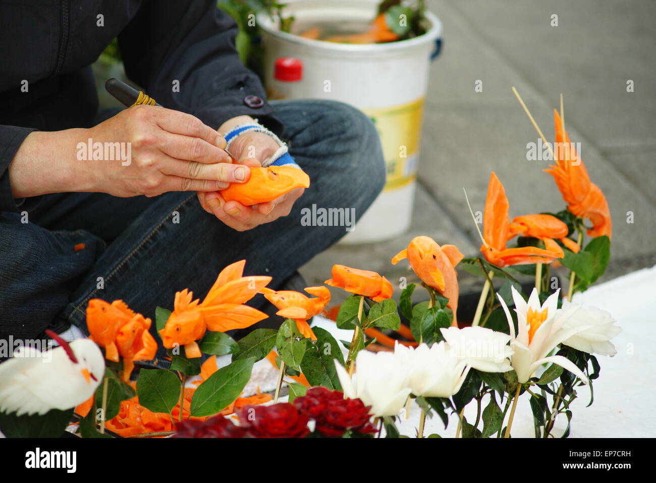 Streetart-Künstler machen Arbeit an Karotten und Gemüse Stockfoto