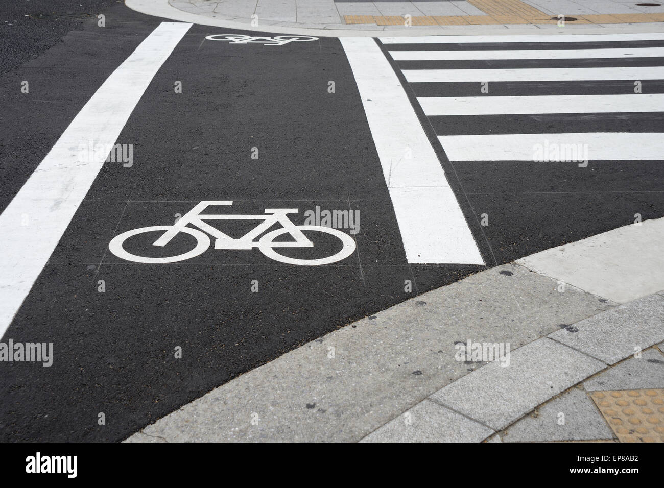 Fahrrad-Zeichen neben Zebrastreifen in Stadt für Radweg auf der Straße  Stockfotografie - Alamy