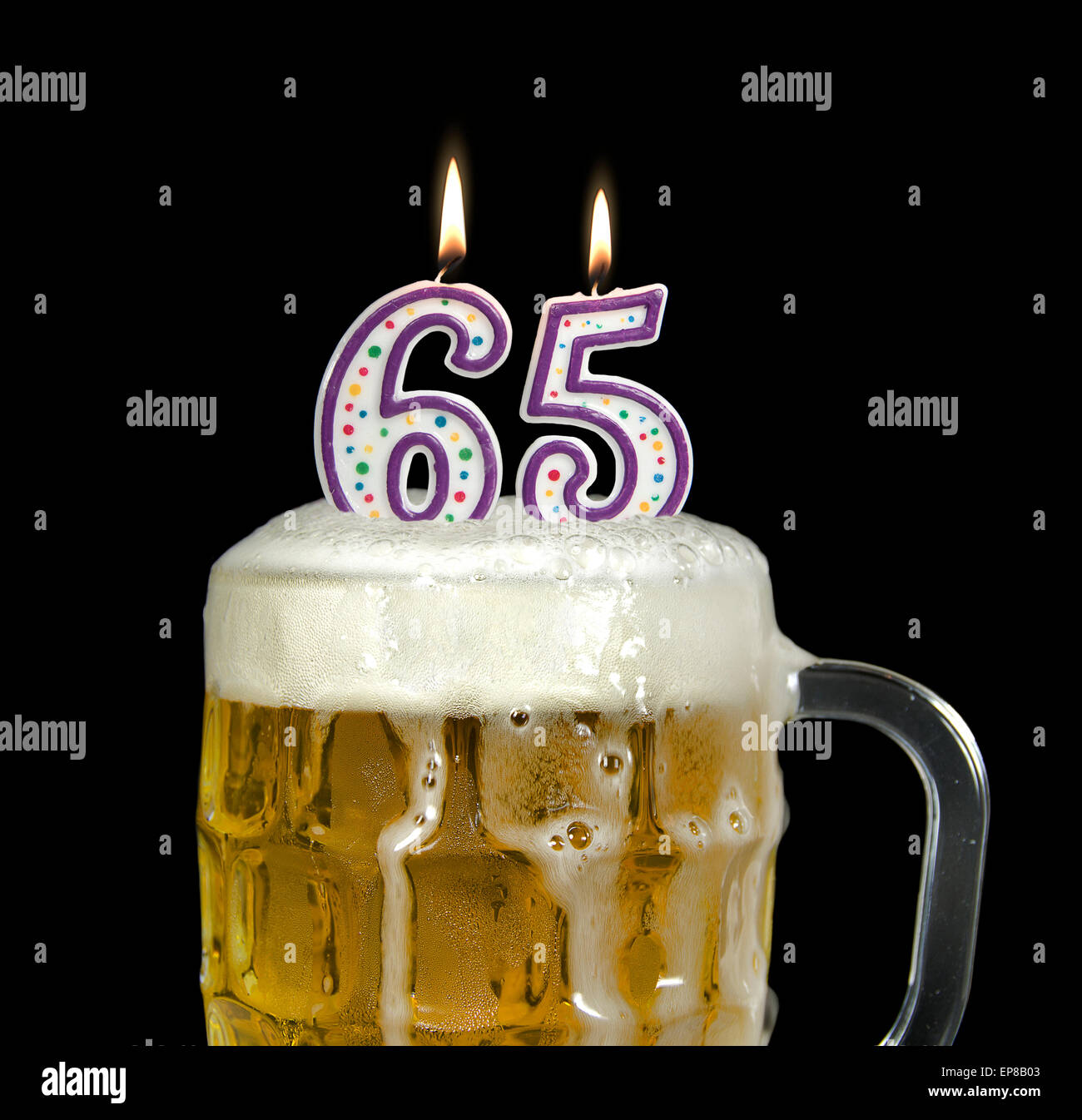 Beleuchteten Geburtstagskerzen im Krug Bier zum 65. Geburtstag, isoliert auf schwarz. Stockfoto