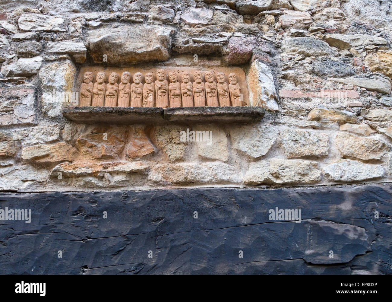 Zwölf Apostel und Maria Skulptur. Über einen hölzernen Türsturz einer Tür im alten Dorf eine kleine Schnitzerei von Heiligen, eines mit einem Schlüssel Stockfoto