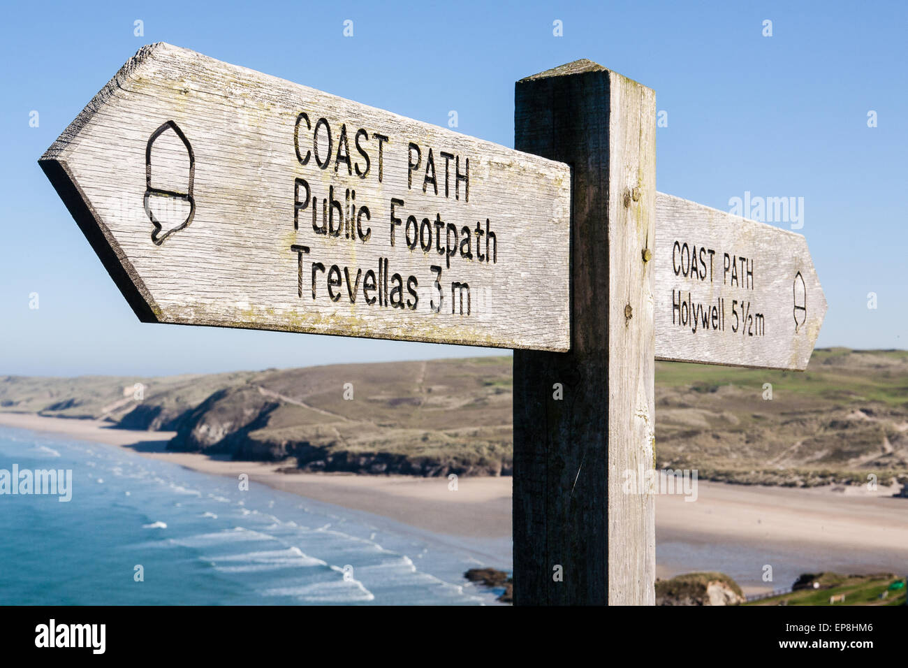 Wegweiser für South West Coast Path, Großbritanniens längsten Wanderweg und ein National Trail, wie durch das Eichel-Symbol auf dem Schild oben Dünenwanderungen Sand Strand von Perranporth, einem beliebten Badeort in Nord Cornwall, England. Stockfoto