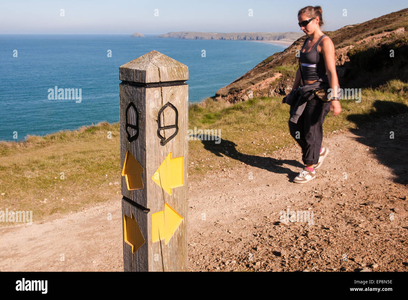 Wandern auf South West Coast Path, Großbritanniens längsten Wanderweg und ein National Trail, wie durch die Eichel-Symbol am Thie Signp angegeben Stockfoto