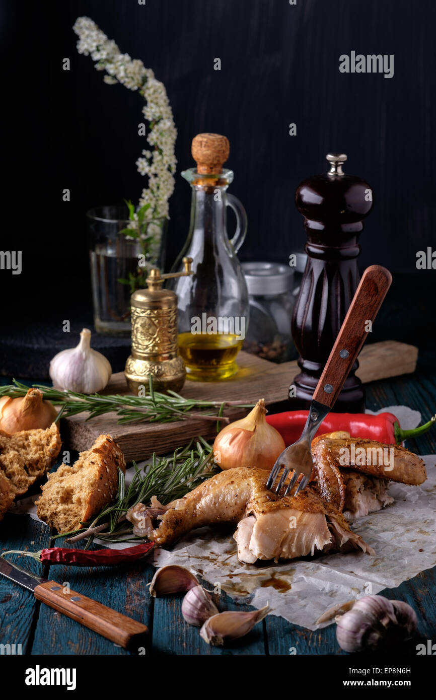 Gebratene Hähnchenschenkel und Flügel mit Gewürzen und Kräutern auf einem Holztisch. Leckeres Essen. Rustikalen Stil. Stockfoto