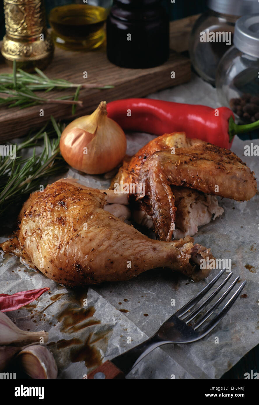 Gebratene Hähnchenschenkel und Flügel mit Gewürzen und Kräutern auf einem Holztisch. Leckeres Essen. Rustikalen Stil. Stockfoto