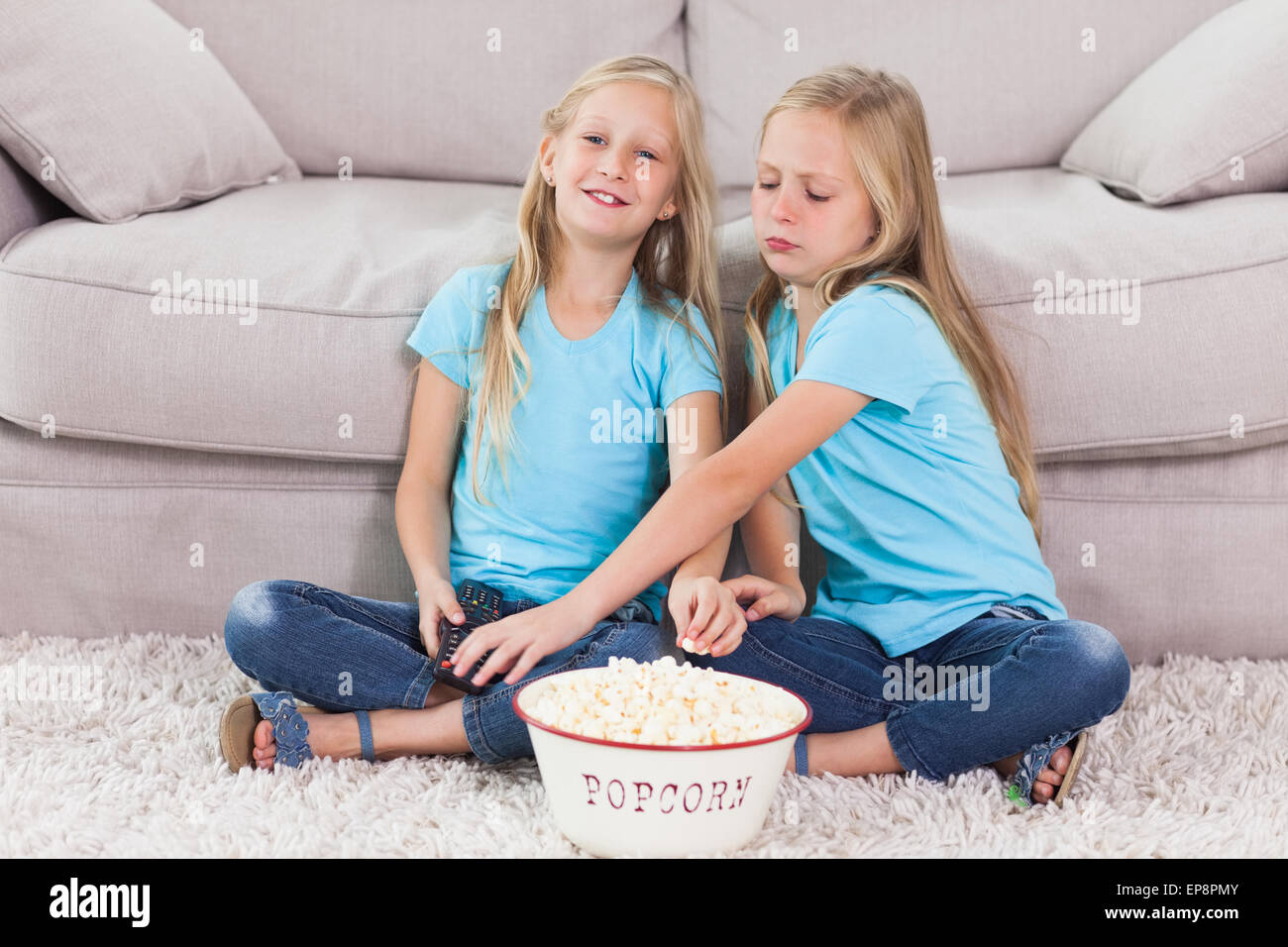 Junge Zwillinge Essen Popcorn sitzt auf einem Teppich Stockfoto