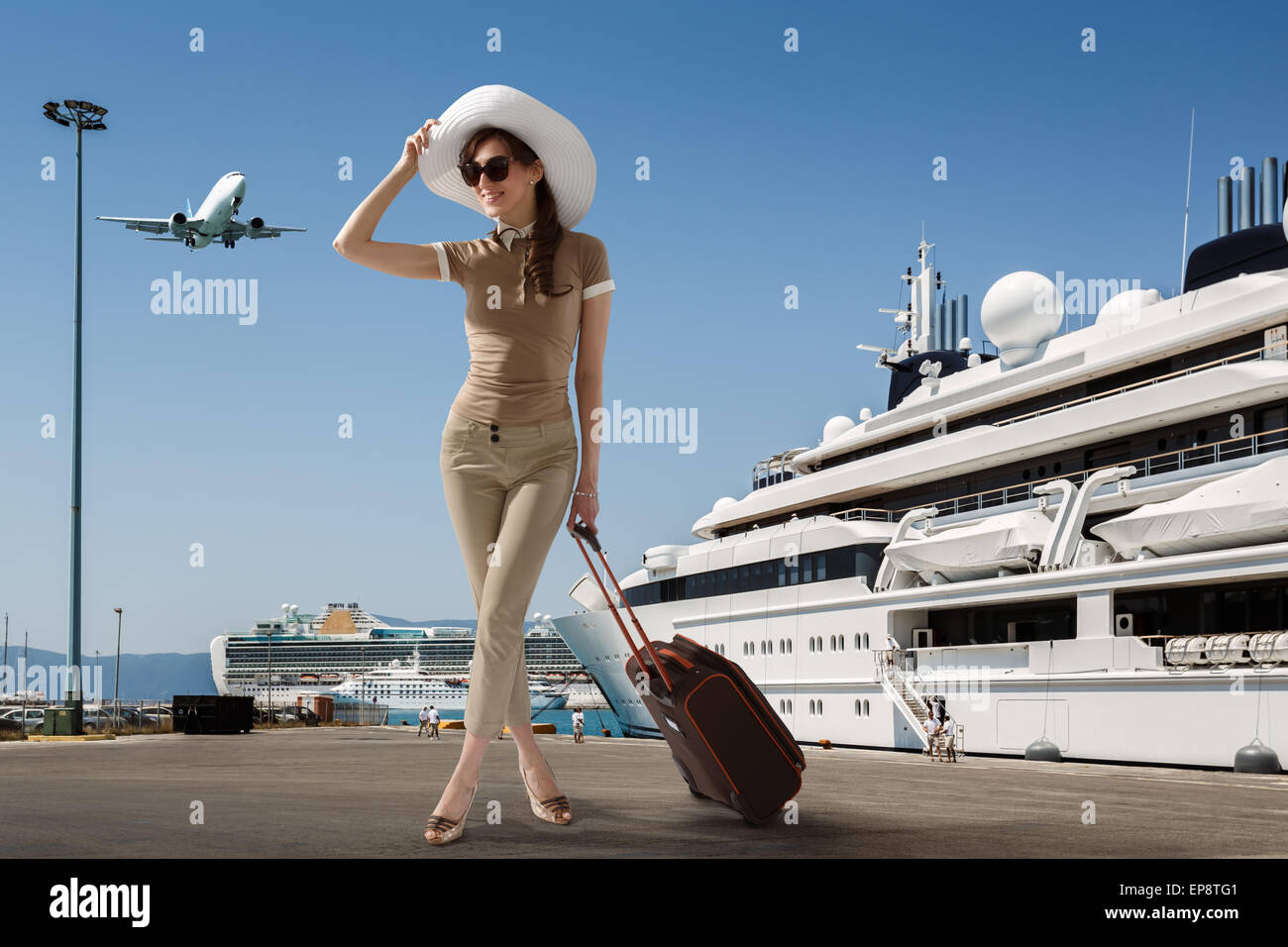 Stilvolle schlanke Frau tragen Sonnenbrillen und weißen Hut stehen im Hafen in der Nähe von angedockten Kreuzfahrtschiff Stockfoto