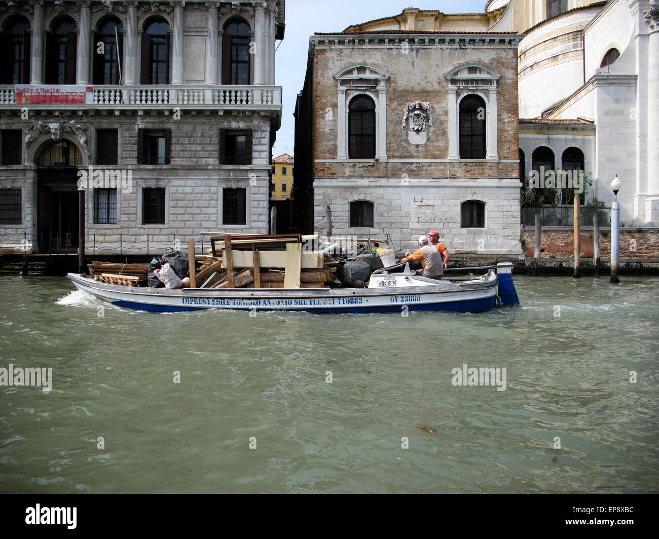 Ein Arbeitsboot mit Holz und waren am Canal Grande in Venedig Stockfoto