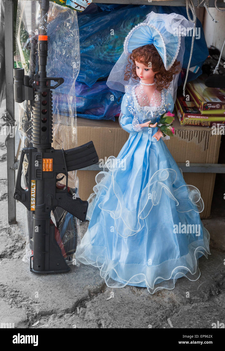 Braut des Prinzen Puppe und Maschinengewehr Spielzeug nebeneinander, Bazar, Zahedan, Iran Stockfoto