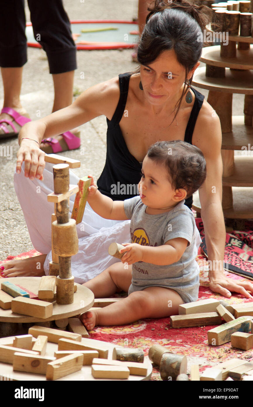 Mutter hilft ihrem Sohn einen Turm mit Holzklötzen bauen Stockfoto