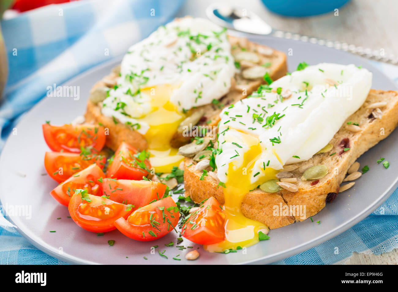 Frühstücks-Sandwich mit pochiertem Ei und Cherry-Tomaten. Stockfoto