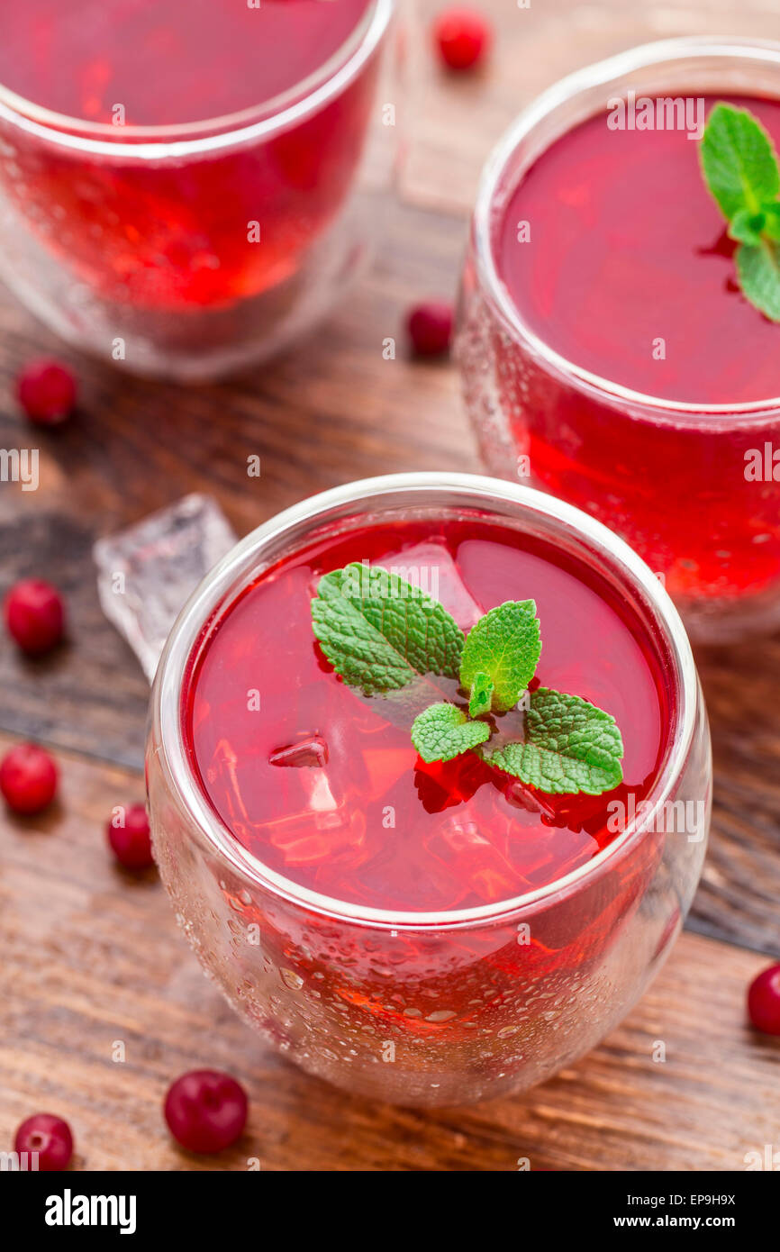 Cranberry-cocktail mit Minze garniert auf einem Holztisch Stockfoto