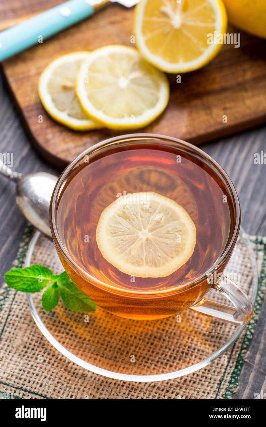 Tasse Tee mit Minze und Zitrone auf Holztisch Stockfoto