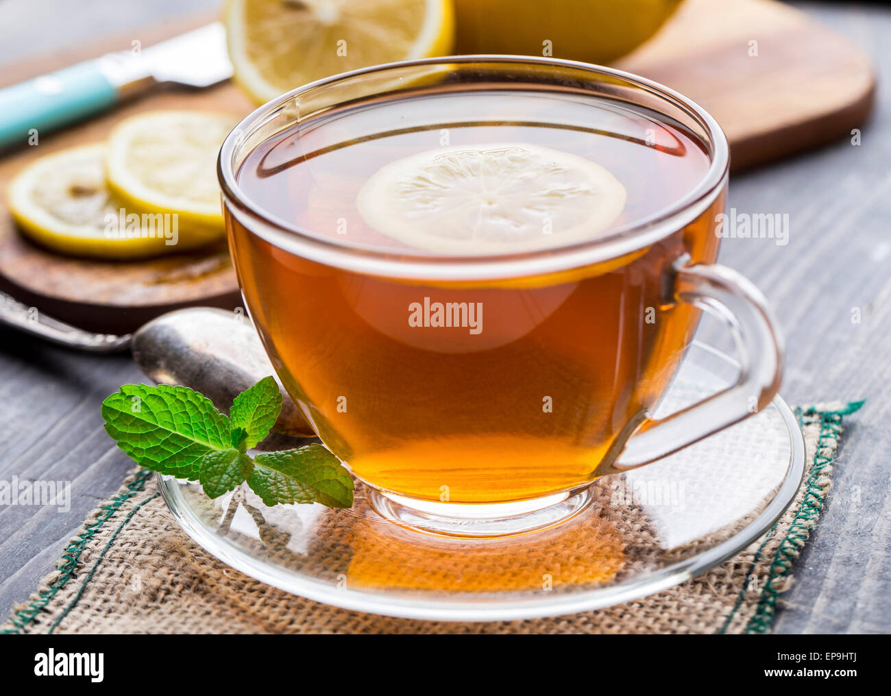 Tasse Tee mit Minze und Zitrone auf Holztisch Stockfoto