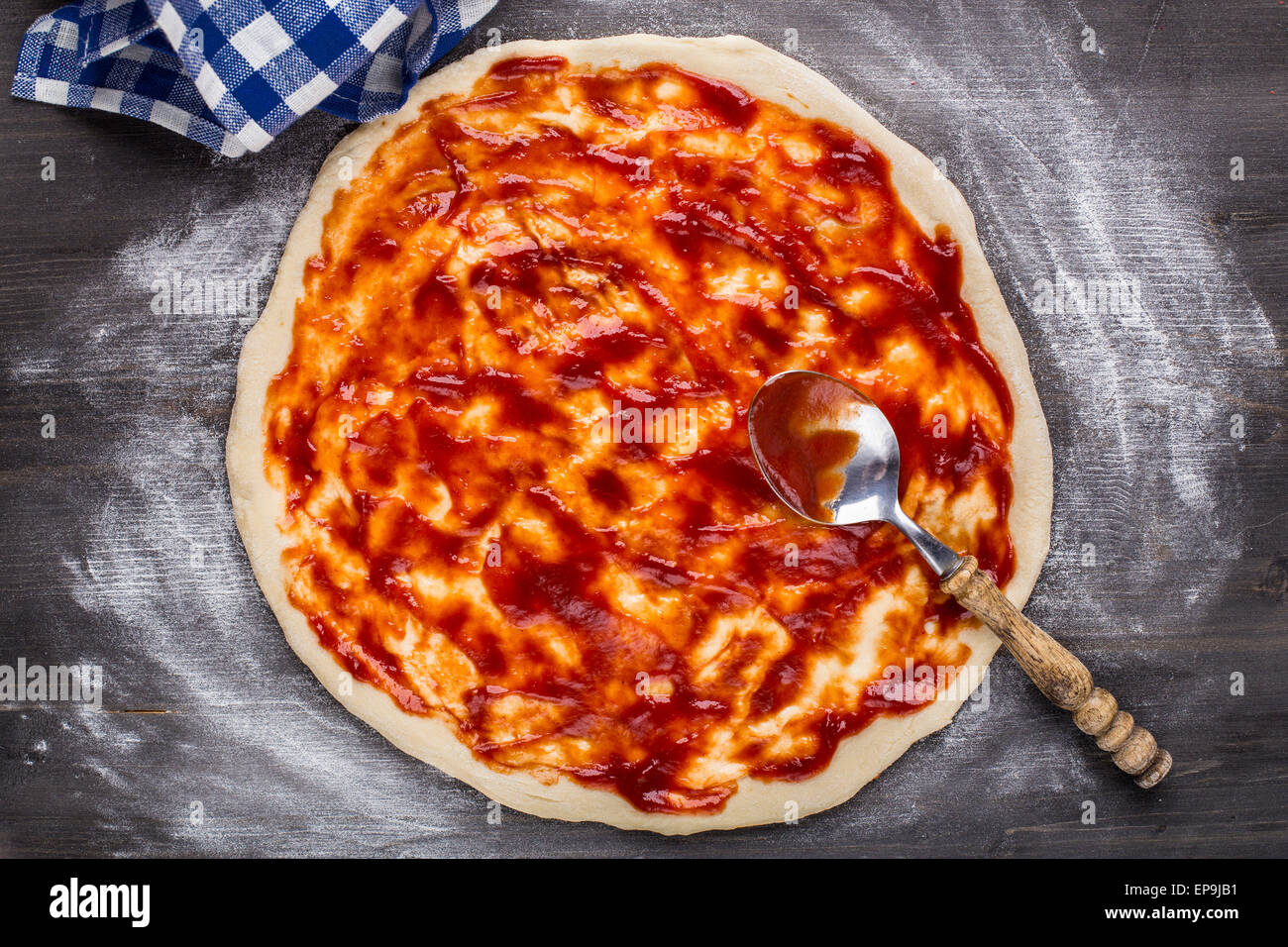 Herstellung von Pizza. Tomatensauce auf ein Teig Stockfoto