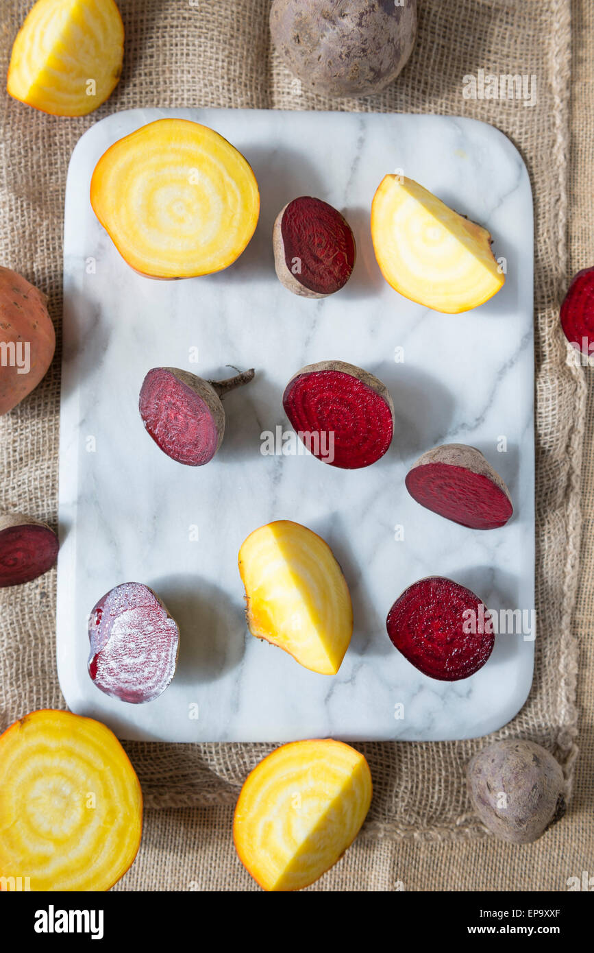 Rote Beete und goldenen rote Beete auf ein Schneidebrett Marmor. Stockfoto