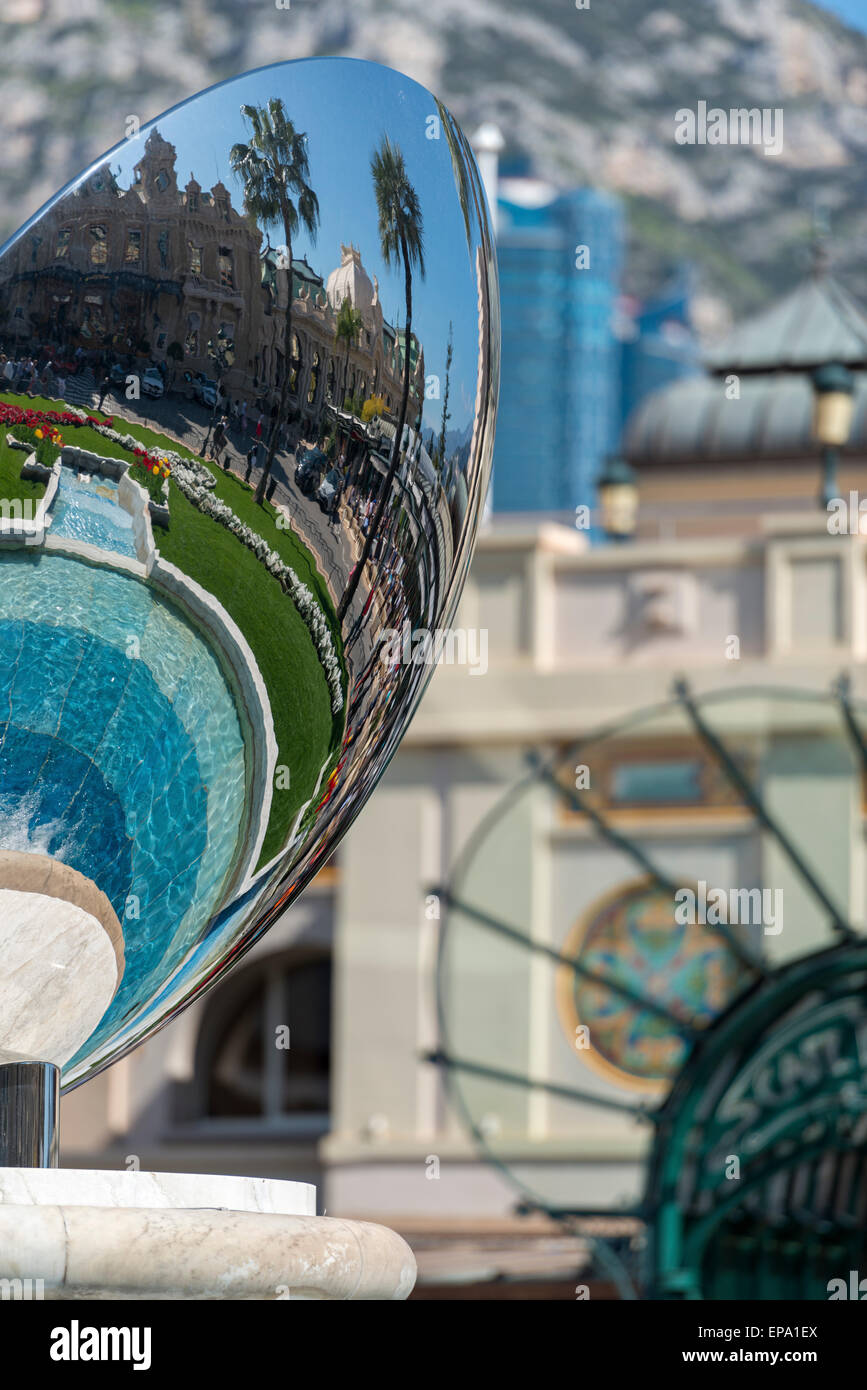 Ein Spiegelbild des Kasinos in einem Metall-Skulptur und Cafe de Paris Eingang im Hintergrund in Monte Carlo, Monaco Stockfoto