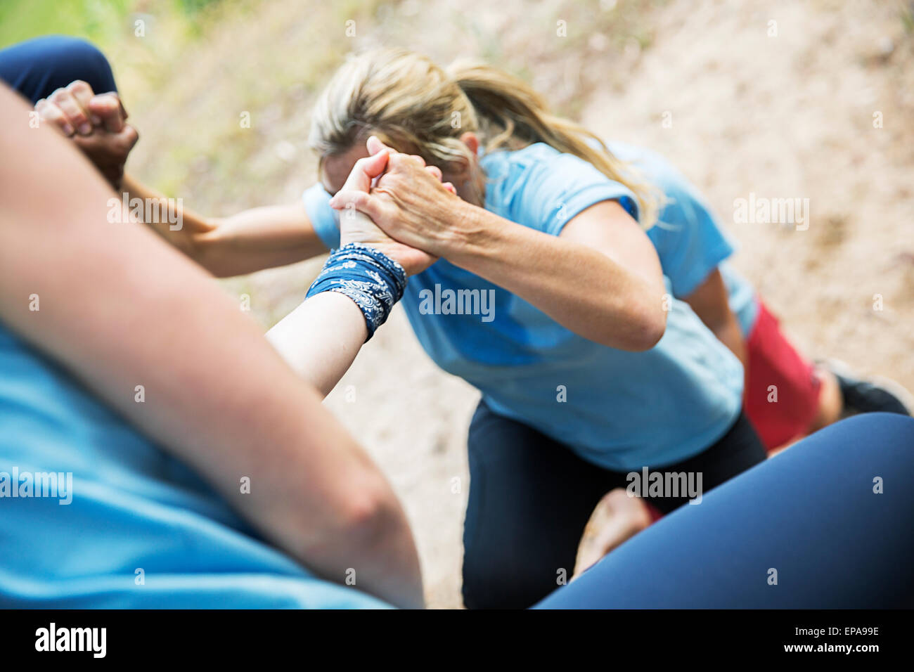 hilft Frau Bootcamp-Hindernis-Parcours klettern Stockfoto