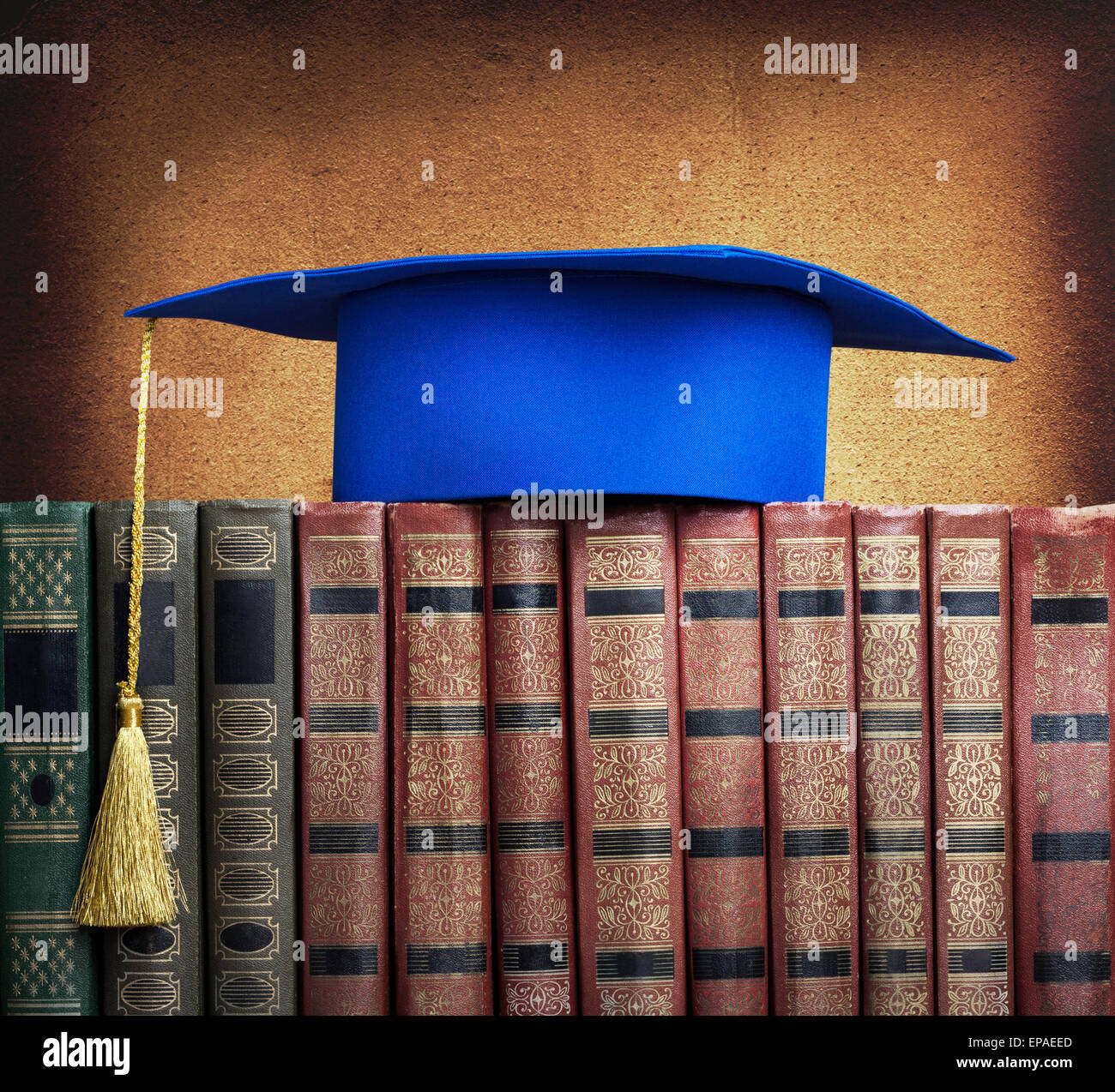 Graduierung Quaste auf Stapel Bücher auf abstrakten Hintergrund der Wand Stockfoto