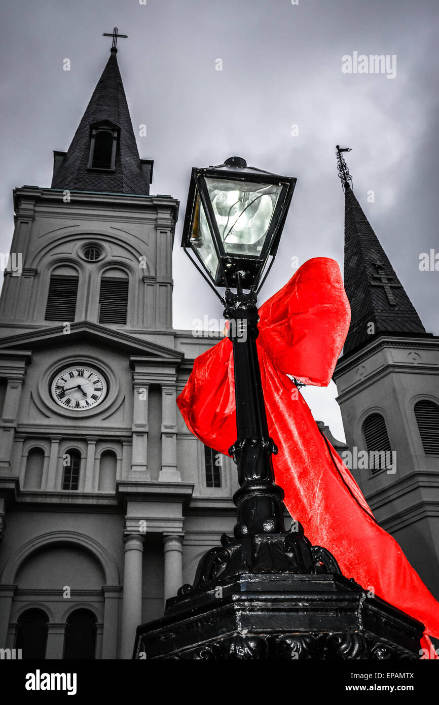 Große rote Bögen hängen an Laternenmasten in der Nähe von St. Louis Cathedral, Jackson Square im French Quarter in New Orleans, LA Stockfoto