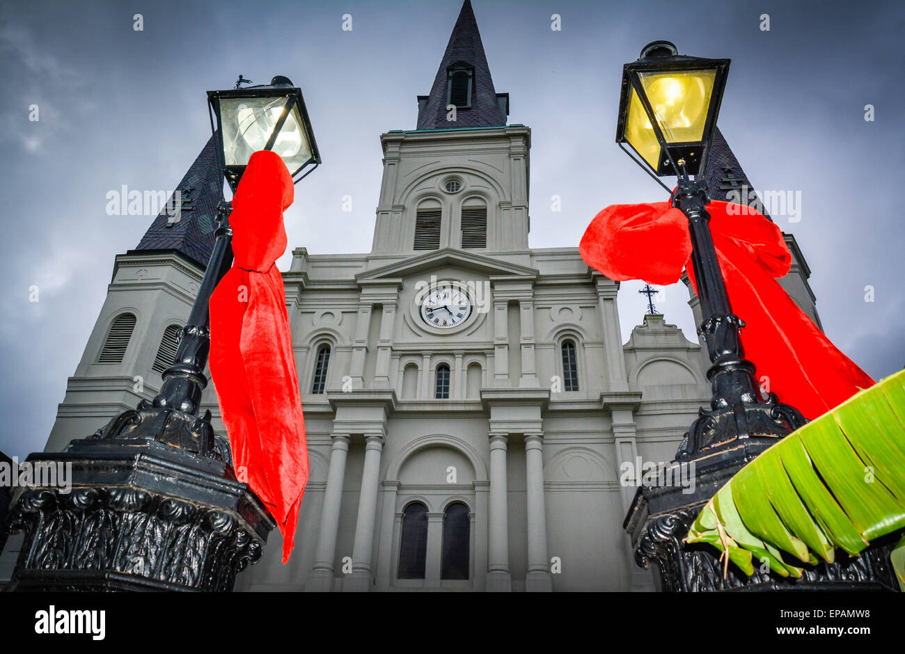 Große rote Bögen hängen an Laternenmasten in der Nähe von St. Louis Cathedral, Jackson Square im French Quarter in New Orleans, LA Stockfoto