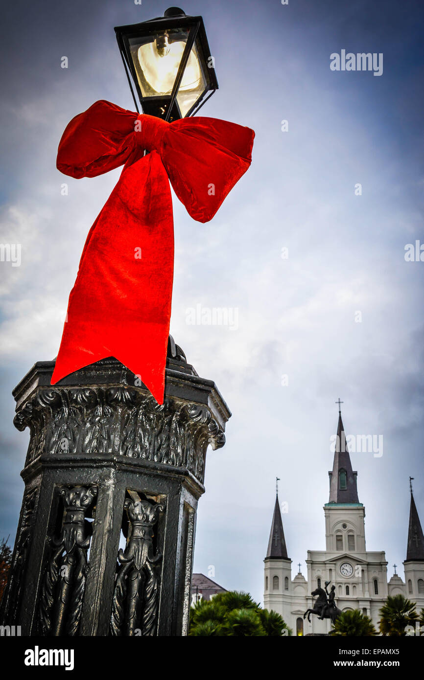 Riesige rote Bögen sind um Laternenmasten am Eingang zum Jackson Square im French Quarter in New Orleans, LA gebunden. Stockfoto