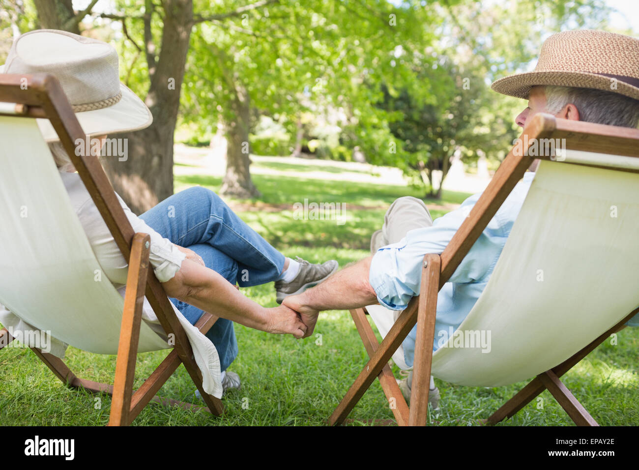 Älteres paar sitzen in Liegestühlen im park Stockfoto