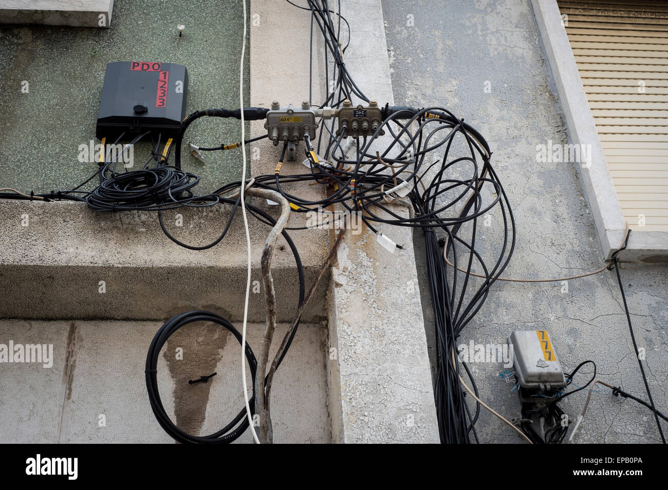 Drähte und Kabel für Strom und Telefon an der Wand eines Wohnhauses in  Lissabon Portugal Stockfotografie - Alamy