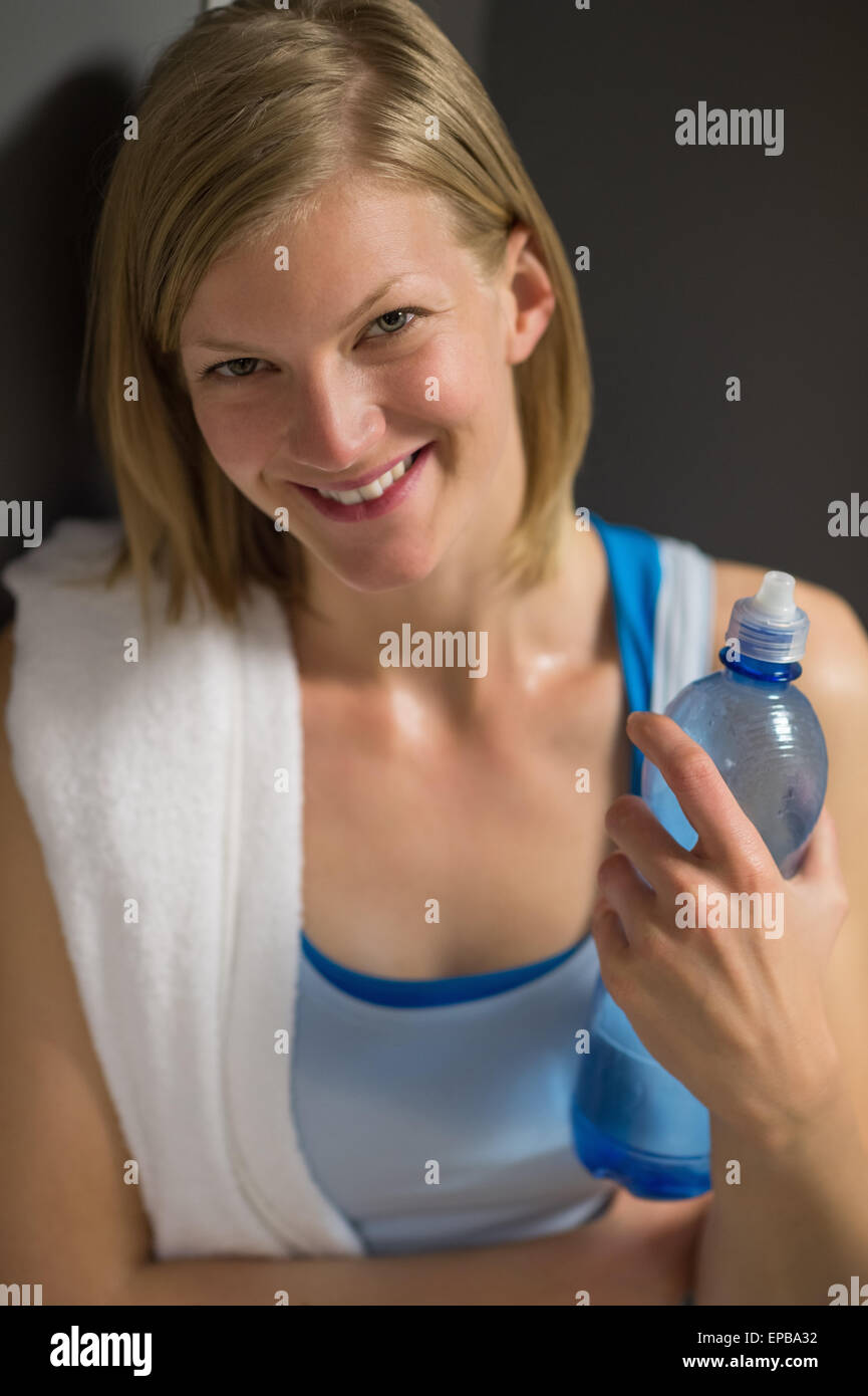 Frau mit Wasserflasche in Umkleidekabine Stockfoto