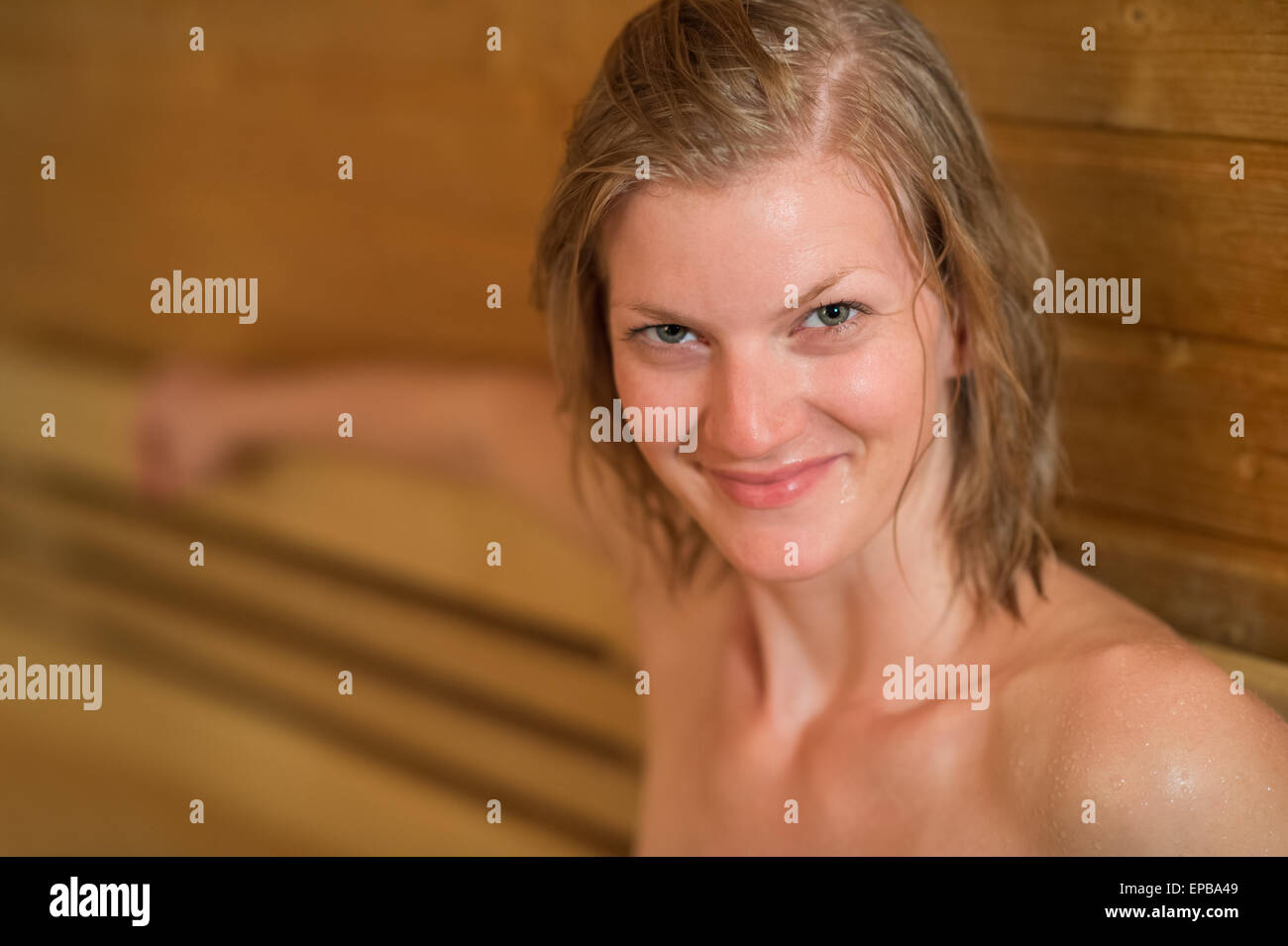 Lächelnde verschwitzt Frau in sauna Stockfoto