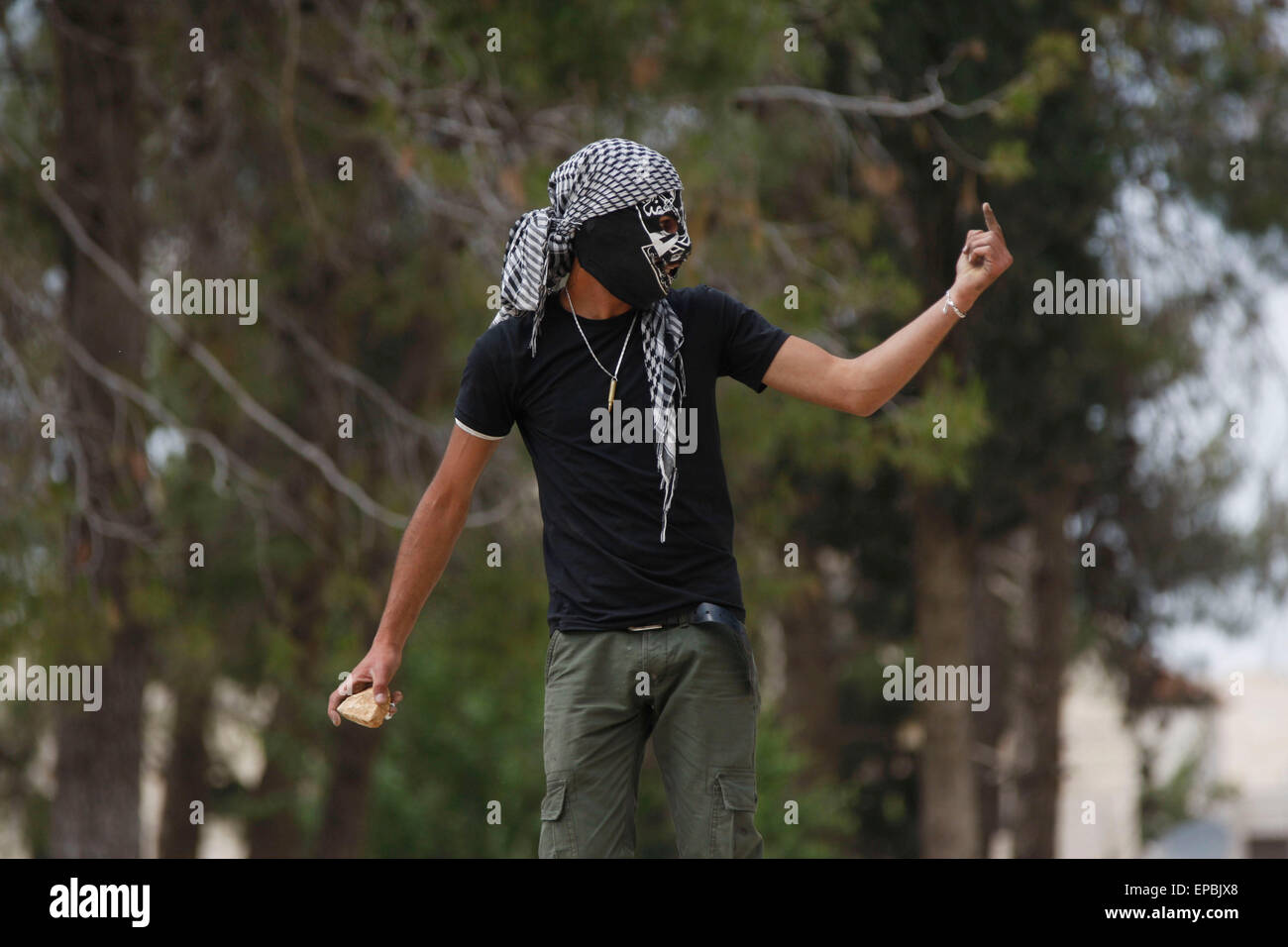 Ramallah. 15. Mai 2015. Eine palästinensische Demonstranten macht eine aggressive Geste auf israelische Soldaten bei Zusammenstößen, die nach einem Protest zum 67. Jahrestag der "Nakba" in der West Bank Dorf Nilin in der Nähe von Ramallah, am 15. Mai 2015. Nakba Day, oder Tag der "Katastrophe" in Arabisch, ist eine jährliche Gedenkfeier für palästinensische Klage über Israels Gründung 1948 und ihre Verschiebung während des Krieges in seinem Gefolge. Bildnachweis: Fadi Aruri/Xinhua/Alamy Live-Nachrichten Stockfoto