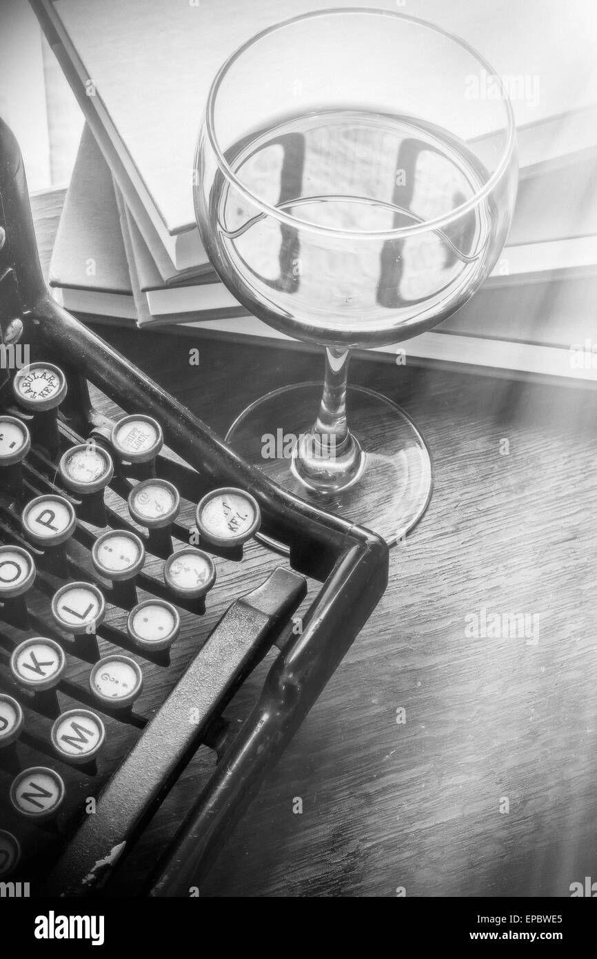 Alte Vintage Schreibmaschine mit Glas Wein Stifte und Bücher in diesem Retro-kreatives Schreiben und suchen unter dem Motto Tischplatte Stockfoto