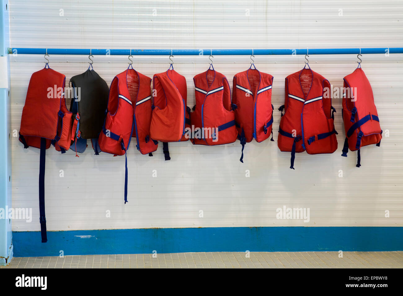 Neben einem Innenpool hängen Rettungswesten Stockfoto
