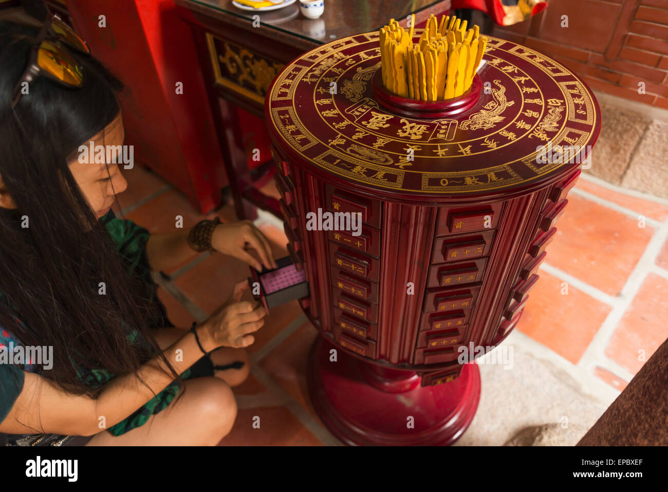 Chinesische junge Frau, die versucht der traditionelle Rolle des Schicksals in einem buddhistischen Tempel; Shanzidou, Insel Kinmen, Taiwan Stockfoto