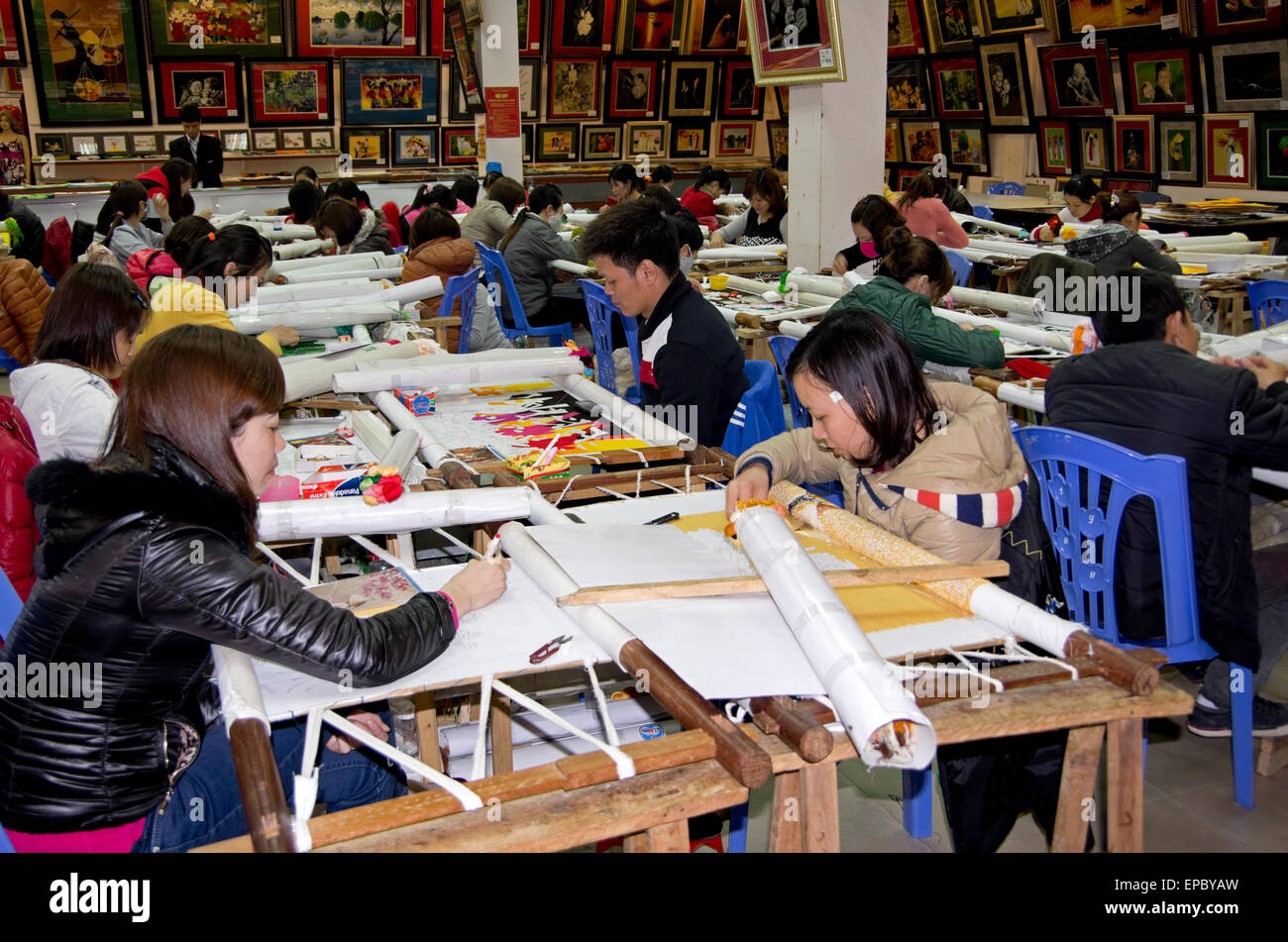 Frauen und Männer arbeiten auf handgemachte Seidenstickerei Bilder in Seitenanschlag touristischen Straße zwischen Hanoi und Halong. Stockfoto