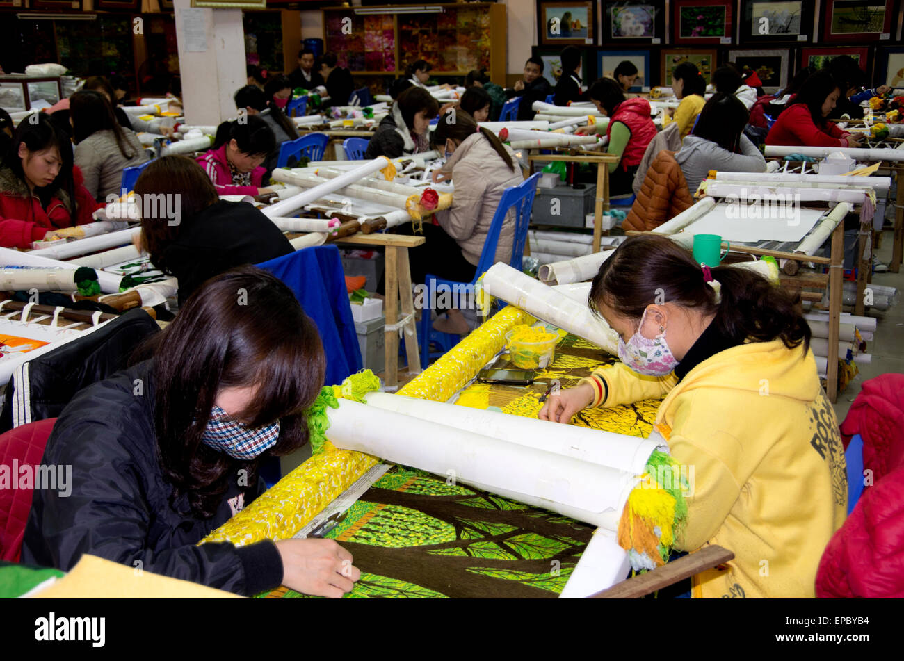 Frauen und Männer arbeiten auf handgemachte Seidenstickerei Bilder in Seitenanschlag touristischen Straße zwischen Hanoi und Halong. Stockfoto