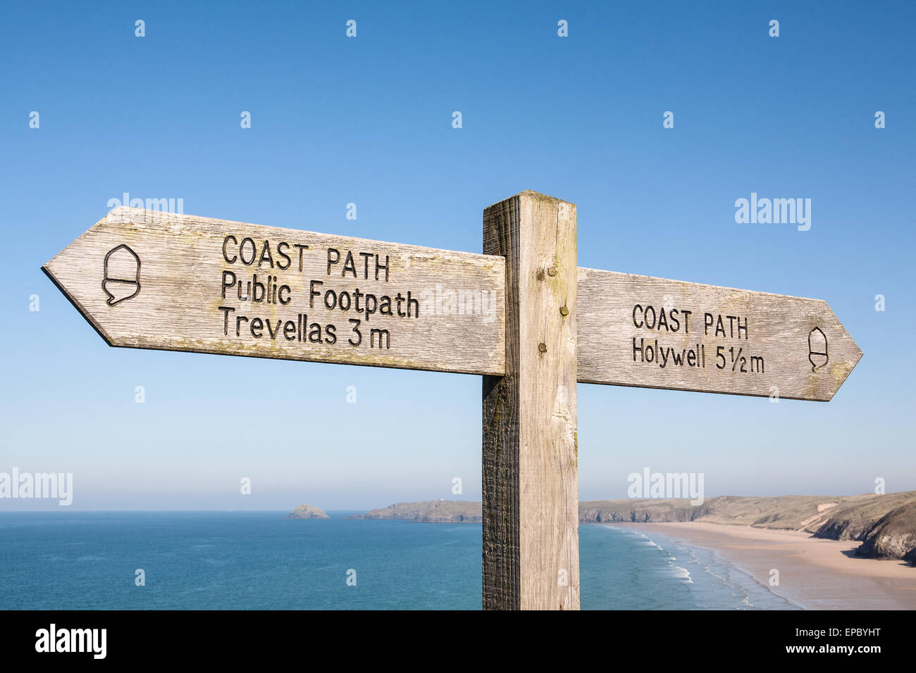 Wegweiser auf South West Coast Path, Großbritanniens längsten Wanderweg und ein National Trail, wie durch das Eichel-Symbol auf dem Schild oben Dünenwanderungen Sand Strand von Perranporth, einem beliebten Badeort in Nord Cornwall, England. Stockfoto