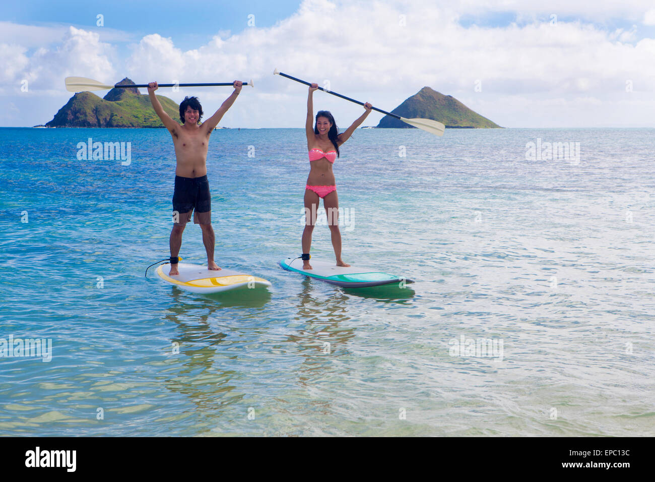 japanisches Paar auf Stand up Paddleboards in hawaii Stockfoto
