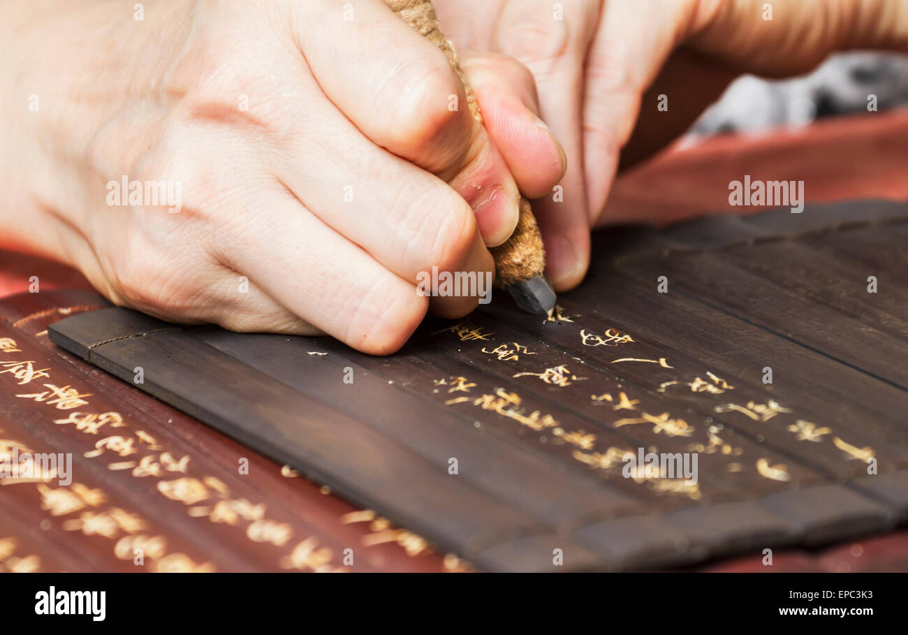 Frau schnitzen Inschriften auf Holzplatten, Xidi, Anhui, China Stockfoto